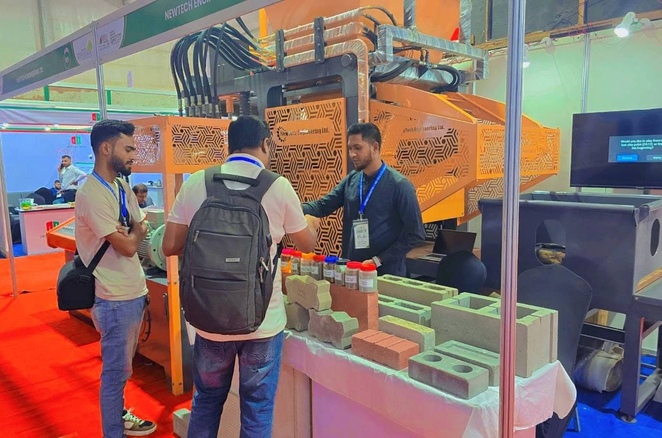 NewTech engineers explaining block and paver samples to expo visitors